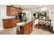Open kitchen featuring a center island, wood cabinets, and seamless connection to the eat-in and living areas at 15606 Montesino Dr, Orlando, FL 32828