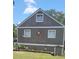 Side view of home featuring wood siding, green roof, and an ornamental sun decoration on the wall at 1717 Se 190Th Ave, Silver Springs, FL 34488