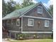 Charming home with a green metal roof, well-kept landscaping, and unique sun decoration on the front wall at 1717 Se 190Th Ave, Silver Springs, FL 34488