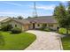Well-maintained home with a tile roof, paver driveway, attached garage, and landscaped front yard at 1721 Perch Ln, Sanford, FL 32771