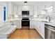Modern kitchen with white cabinets, stainless steel appliances, stylish backsplash, and a breakfast bar at 1721 Perch Ln, Sanford, FL 32771