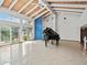 Spacious living room with tile flooring, a piano, large windows, and access to the outdoors at 1721 Perch Ln, Sanford, FL 32771