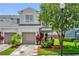 Charming two-story townhome featuring a well-manicured lawn, a one-car garage, and colorful landscaping at 1784 Fritwell Ct, Ocoee, FL 34761