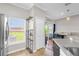 Bright kitchen with white cabinets, tile floors, and a sliding glass door that leads to a deck at 1784 Fritwell Ct, Ocoee, FL 34761