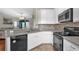 Well-lit kitchen with white cabinets, stainless steel appliances, and a view into the living room at 1784 Fritwell Ct, Ocoee, FL 34761