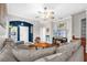 Cozy living room featuring an arched doorway, hardwood floors, and a large comfortable couch at 1784 Fritwell Ct, Ocoee, FL 34761