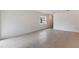 Simple living room with neutral tile flooring, a window providing natural light, and a minimalist aesthetic at 196 Duckweed Ave, Fruitland Park, FL 34731