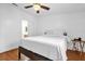 Bright bedroom featuring hardwood floors, a ceiling fan, and neutral decor with a sliding-door to the bathroom at 222 Ellsworth Dr, Kissimmee, FL 34758