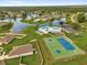 Aerial view of a community with lake, pool, tennis courts and well-maintained landscapes at 222 Ellsworth Dr, Kissimmee, FL 34758