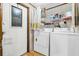 Laundry room features new washer and dryer units and storage shelving with cleaning supplies at 222 Ellsworth Dr, Kissimmee, FL 34758