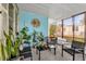 The screened-in porch features blue paneled walls, a variety of potted plants, and comfortable outdoor seating at 222 Ellsworth Dr, Kissimmee, FL 34758