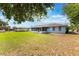 A view of the home's backyard with lush green lawn and a screened-in lanai at 2290 Carson Ln, Deltona, FL 32738