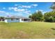 Home featuring a large grassy backyard and an enclosed screened lanai at 2290 Carson Ln, Deltona, FL 32738