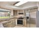 Kitchen with stainless steel refrigerator and wood-look cabinets and countertops with a window view at 2290 Carson Ln, Deltona, FL 32738