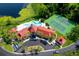 Aerial view of community clubhouse, pool, tennis courts, parking, and lake with foliage at 236 Afton Sq # 309, Altamonte Springs, FL 32714