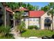 Condo exterior features a red roof, neutral siding, and balconies amidst lush landscaping at 236 Afton Sq # 309, Altamonte Springs, FL 32714