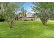 Well-manicured front yard with lush green grass and mature trees, offering curb appeal at 244 Surf Scooter Dr, Daytona Beach, FL 32119