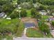 Aerial view of the home nestled on a grassy lot amid lush trees in a peaceful neighborhood at 2549 Gress Ln, Lakeland, FL 33805