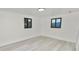 Clean bedroom featuring updated floors, natural light from two windows, and neutral white walls at 2549 Gress Ln, Lakeland, FL 33805