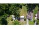 An aerial view of property with large lawn, mature trees, boats, and a storage building next to a well-maintained home at 2597 Cr 426F, Lake Panasoffkee, FL 33538