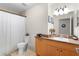 Well-lit bathroom featuring a vanity with sink, toilet, shower curtain, and tile flooring at 2597 Cr 426F, Lake Panasoffkee, FL 33538