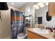 A view of the bathroom, with tile shower, themed shower curtain and matching toilet seat cover at 2597 Cr 426F, Lake Panasoffkee, FL 33538