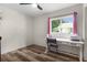 Bright bedroom featuring wood-look floors, a ceiling fan, and a large window for natural light at 2597 Cr 426F, Lake Panasoffkee, FL 33538