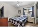 Cozy bedroom with a checkered comforter, window view, and light wood flooring at 2597 Cr 426F, Lake Panasoffkee, FL 33538