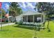 Well-maintained home exterior with a screened porch, showcasing a lush front yard with beautiful landscaping at 2597 Cr 426F, Lake Panasoffkee, FL 33538