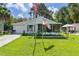 Charming single-story home with a well-manicured lawn, screened in porch, and American flags displayed at 2597 Cr 426F, Lake Panasoffkee, FL 33538