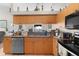 Kitchen featuring wooden cabinets, stainless steel dishwasher, and double basin sink at 2597 Cr 426F, Lake Panasoffkee, FL 33538