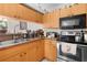 Well-equipped kitchen with stainless steel appliances, double sink, and wooden cabinetry at 2597 Cr 426F, Lake Panasoffkee, FL 33538