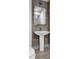 Modern bathroom features a sleek pedestal sink and framed mirror at 260 S Osceola Ave # 1406, Orlando, FL 32801