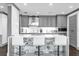 Modern kitchen features marble counters, backsplash, grey cabinets, and a breakfast bar with white chairs at 260 S Osceola Ave # 1406, Orlando, FL 32801
