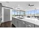 Elegant kitchen with custom gray cabinetry, stainless steel appliances, and a view of the combined dining and living area at 260 S Osceola Ave # 1406, Orlando, FL 32801