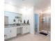 Bright bathroom with double sinks, a large mirror, and a walk-in shower at 2924 Protagonist St, Kissimmee, FL 34746