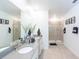 This bright bathroom features double sinks, neutral walls, and a large glass door shower at 2924 Protagonist St, Kissimmee, FL 34746