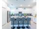 This kitchen features a central island with bar stools, stainless steel appliances, and sleek, white cabinetry at 2924 Protagonist St, Kissimmee, FL 34746