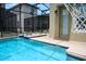 Backyard pool and hot tub area with screened enclosure and basketball net at 2924 Protagonist St, Kissimmee, FL 34746