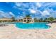 Community pool featuring lounge chairs and umbrellas under a partly cloudy sky at 2924 Protagonist St, Kissimmee, FL 34746