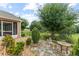 Charming backyard featuring a stone patio, lush landscaping, and picturesque views of the adjacent green space at 30108 Pga Dr, Sorrento, FL 32776