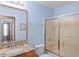 A blue bathroom with a granite countertop, a sink, and a glass door shower at 30108 Pga Dr, Sorrento, FL 32776