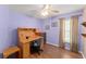 Bedroom with purple walls, ceiling fan, wooden floors, and desk at 30108 Pga Dr, Sorrento, FL 32776
