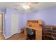 Bedroom with purple walls, ceiling fan, wooden floors, and a desk at 30108 Pga Dr, Sorrento, FL 32776