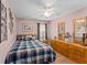 Cozy bedroom with a plaid bedspread, wooden furniture, and ceiling fan at 30108 Pga Dr, Sorrento, FL 32776