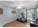 Bedroom with hardwood floors, elliptical machine, and ceiling fan at 30108 Pga Dr, Sorrento, FL 32776