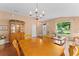 Comfortable dining room area with a classic chandelier, a view, and wood floors at 30108 Pga Dr, Sorrento, FL 32776