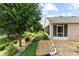 Landscaped backyard with a stone patio, surrounded by lush greenery and peaceful views at 30108 Pga Dr, Sorrento, FL 32776