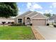 Charming single-story home featuring manicured lawn, flowerbeds, and an attached two-car garage at 30108 Pga Dr, Sorrento, FL 32776