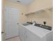 Laundry room featuring a washer, dryer, and wire rack shelving at 30108 Pga Dr, Sorrento, FL 32776